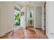 Bright foyer with a stylish cowhide rug, a view of the front garden, and an elegant light fixture at 6930 Wesley Hughes Rd, Cumming, GA 30040