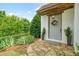 Inviting front door with a wreath, flanked by potted plants and complemented by lush greenery at 6930 Wesley Hughes Rd, Cumming, GA 30040