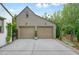 Two-car garage featuring a concrete driveway, carriage lights, and a manicured topiary between doors at 6930 Wesley Hughes Rd, Cumming, GA 30040