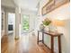 Light-filled hallway featuring wood floors, neutral walls, and a glass-paneled door at 6930 Wesley Hughes Rd, Cumming, GA 30040