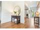 Hallway with shiplap walls, hardwood floors, and a gold-framed mirror above a wooden table at 6930 Wesley Hughes Rd, Cumming, GA 30040