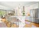 Kitchen island with a white, paneled base, marble countertop, and rattan counter stools at 6930 Wesley Hughes Rd, Cumming, GA 30040