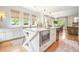 Bright kitchen featuring an island with a microwave, marble countertops, and hardwood floors at 6930 Wesley Hughes Rd, Cumming, GA 30040