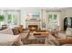 Inviting living room features a cozy fireplace, comfortable seating, and natural light from large windows at 6930 Wesley Hughes Rd, Cumming, GA 30040