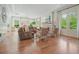 Expansive living room with hardwood floors, a fireplace, large windows, and a comfortable seating area at 6930 Wesley Hughes Rd, Cumming, GA 30040