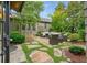 Stone patio with outdoor seating, surrounded by lush landscaping and greenery at 6930 Wesley Hughes Rd, Cumming, GA 30040