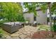 Beautifully furnished outdoor patio with stone flooring and mature trees for shade and privacy at 6930 Wesley Hughes Rd, Cumming, GA 30040