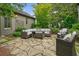 Inviting stone patio with comfortable wicker furniture and meticulous landscaping at 6930 Wesley Hughes Rd, Cumming, GA 30040