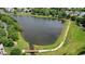 Aerial view of a tranquil pond with a wooden bridge, surrounded by walking paths and lush greenery at 6930 Wesley Hughes Rd, Cumming, GA 30040