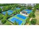 Community tennis courts with beautiful blue surface, a pavilion, surrounded by mature trees and lush landscaping at 6930 Wesley Hughes Rd, Cumming, GA 30040
