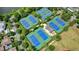 Aerial view of the community's multiple tennis courts, with blue and green surfaces surrounded by trees at 6930 Wesley Hughes Rd, Cumming, GA 30040