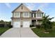 Charming two-story home with a well-manicured lawn, two-car garage, and a welcoming front entrance at 7703 Hansel Ln, Lithonia, GA 30058