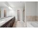 Primary bathroom with double vanity, granite countertops, and a separate tub and shower at 5590 Bright Cross Way, Suwanee, GA 30024