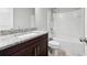 Bathroom features a granite-topped vanity with a combination shower and tub and tile flooring at 5590 Bright Cross Way, Suwanee, GA 30024