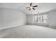 Large primary bedroom with vaulted ceilings, carpet, and a large window at 5590 Bright Cross Way, Suwanee, GA 30024