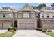 Charming townhome with brick and stone accents, a two-car garage, and well-maintained landscaping at 5590 Bright Cross Way, Suwanee, GA 30024