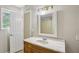 Bathroom featuring a marble countertop, wood vanity, mirror and open doorway at 73 Azalea Dr, Villa Rica, GA 30180