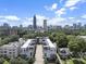 Stunning aerial view of modern townhomes with Atlanta skyline backdrop and beautiful green tree coverage at 133 City View Ne Ct, Atlanta, GA 30308
