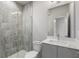 Bathroom featuring gray cabinets and a walk-in shower with gray tile and glass door at 133 City View Ne Ct, Atlanta, GA 30308