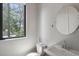 Bright bathroom with a large window offering natural light, complemented by a round mirror above the sink at 133 City View Ne Ct, Atlanta, GA 30308