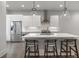 Modern white kitchen featuring a central island with seating, stainless steel appliances, and ample lighting at 133 City View Ne Ct, Atlanta, GA 30308
