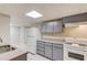 Basement kitchen with gray cabinets, granite counters and white appliances at 1900 Tribble Ridge Dr, Lawrenceville, GA 30045