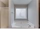 Corner tub in bathroom offers a relaxing retreat with natural light from the nearby window at 1900 Tribble Ridge Dr, Lawrenceville, GA 30045