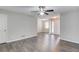 Open-concept living room with wood-look floors, a ceiling fan, and an entryway with a white door at 1900 Tribble Ridge Dr, Lawrenceville, GA 30045