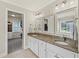 A bathroom with dual sinks, granite countertops, and access to walk in closet at 3675 Ridgeway Ter, Suwanee, GA 30024