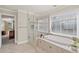 Luxurious bathroom with a separate shower, garden tub, and large window for ample natural light at 3675 Ridgeway Ter, Suwanee, GA 30024