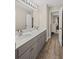 Bathroom features a double sink vanity with gray cabinets, a large mirror, and wood-look flooring at 3675 Ridgeway Ter, Suwanee, GA 30024