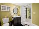 Well-lit bathroom with a black vanity, cabinet, oval mirror, and black and white checkered flooring at 3675 Ridgeway Ter, Suwanee, GA 30024