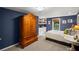 Stylish bedroom with a large armoire, built-in bookshelves, and a neutral color scheme at 3675 Ridgeway Ter, Suwanee, GA 30024