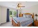 Cozy bedroom with a wooden frame bed, ceiling fan, and natural light streaming through the large window at 3675 Ridgeway Ter, Suwanee, GA 30024