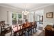 Elegant dining room with hardwood floors, wainscoting, a chandelier, and large windows at 3675 Ridgeway Ter, Suwanee, GA 30024