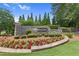 Stone community entrance with lush landscaping and a manicured flowerbed at 3675 Ridgeway Ter, Suwanee, GA 30024