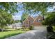 Brick home featuring a two-car garage, a driveway with basketball hoop, and manicured landscaping at 3675 Ridgeway Ter, Suwanee, GA 30024