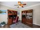 Cozy home office with custom wood bookcases, a ceiling fan, and hardwood floors at 3675 Ridgeway Ter, Suwanee, GA 30024
