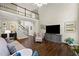 Living room with hardwood floors, a large TV, and access to the upper floor via stairs at 3675 Ridgeway Ter, Suwanee, GA 30024
