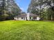 Spacious backyard with a well-maintained lawn and a white house featuring multiple windows at 46 Timber Walk Dr, Sharpsburg, GA 30277