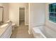 Bathroom featuring white vanity, large mirror, and a tub at 46 Timber Walk Dr, Sharpsburg, GA 30277