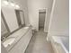 Bathroom featuring double vanity, large mirrors, tub, and closet at 46 Timber Walk Dr, Sharpsburg, GA 30277