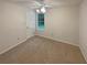 Simple bedroom with carpet, ceiling fan, and a window view of greenery at 46 Timber Walk Dr, Sharpsburg, GA 30277