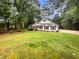 One story home with white siding, black shutters, a well-maintained lawn, and surrounded by tall trees at 46 Timber Walk Dr, Sharpsburg, GA 30277
