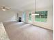 Open living room featuring large windows, fireplace and chandelier lighting at 46 Timber Walk Dr, Sharpsburg, GA 30277