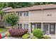 Exterior of a cozy townhome with a well-manicured landscape including shrubs and blooming crepe myrtle at 1810 Ashborough Se Rd # G, Marietta, GA 30067