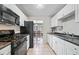 Bright kitchen boasts white cabinetry, black appliances, and a view into the dining room at 1810 Ashborough Se Rd # G, Marietta, GA 30067