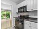 Well-lit kitchen featuring a black range, stainless steel microwave, and white cabinetry at 1810 Ashborough Se Rd # G, Marietta, GA 30067
