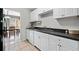 View of the kitchen showing white cabinets, black countertops, and a stainless steel sink at 1810 Ashborough Se Rd # G, Marietta, GA 30067
