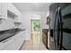 Clean kitchen features white cabinets, black appliances, and view of the backyard at 1810 Ashborough Se Rd # G, Marietta, GA 30067